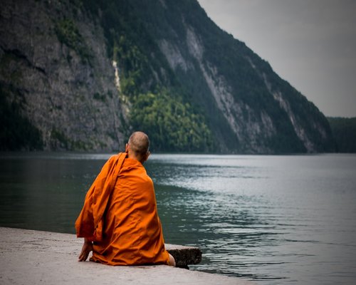 calm person practicing meditation by the lake